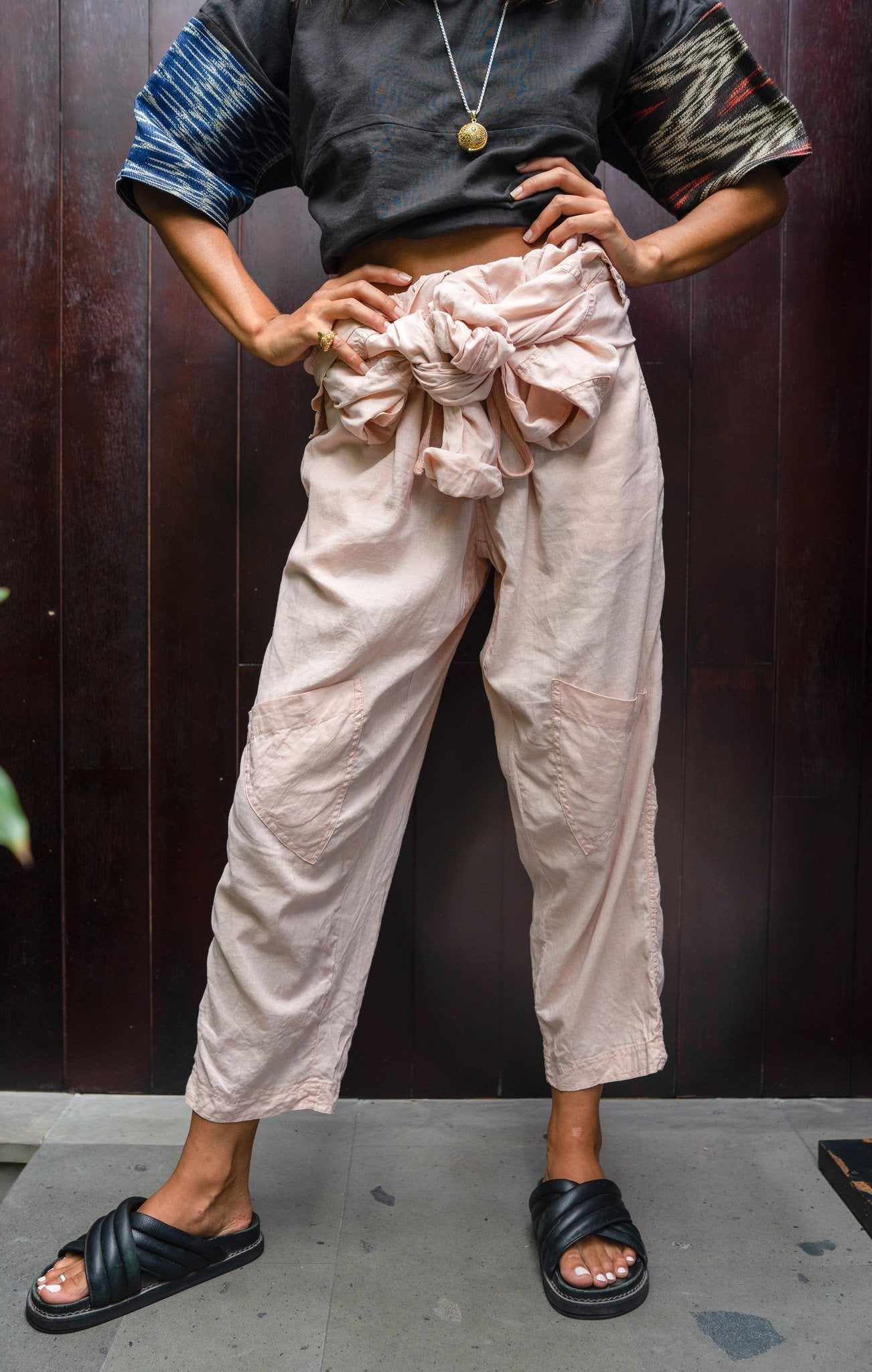 Amira One Tone Coconut Pink Adventure Sail Jumpsuit Catalogue Shot tie at waist zoomed out perspective.